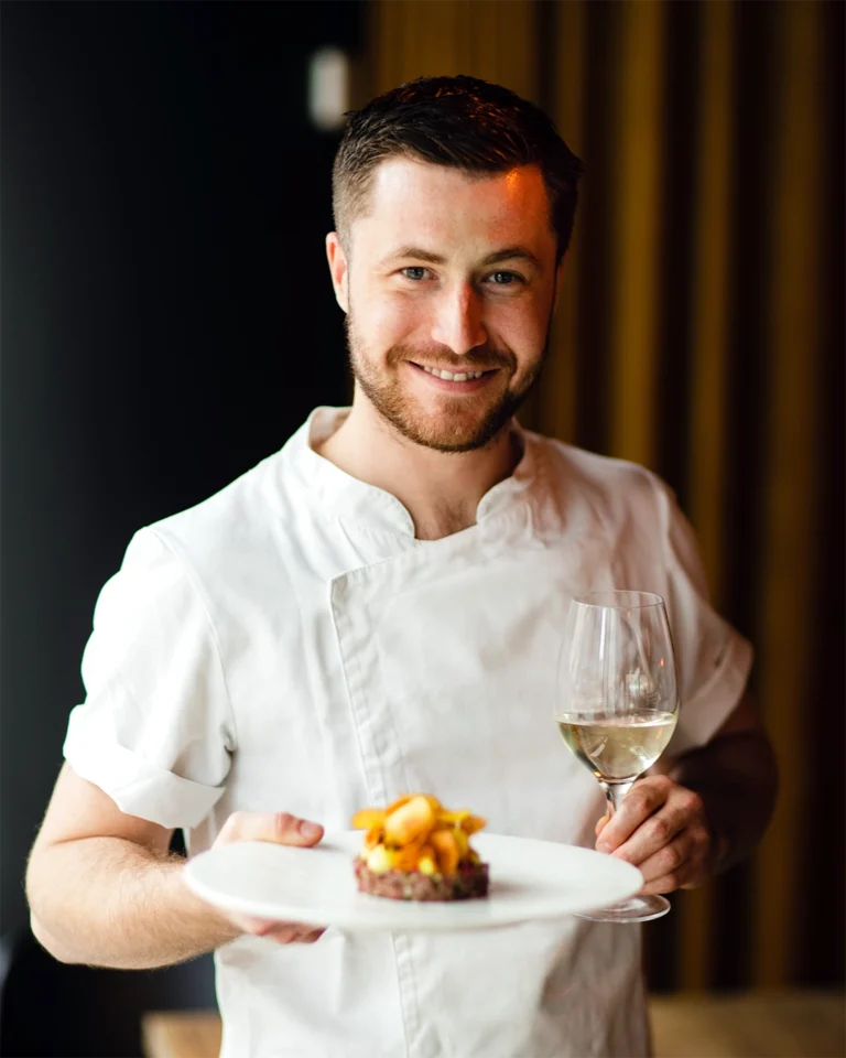 Jacob Jørgsholm from Feed Bistro holds a tartare and a glass of wine